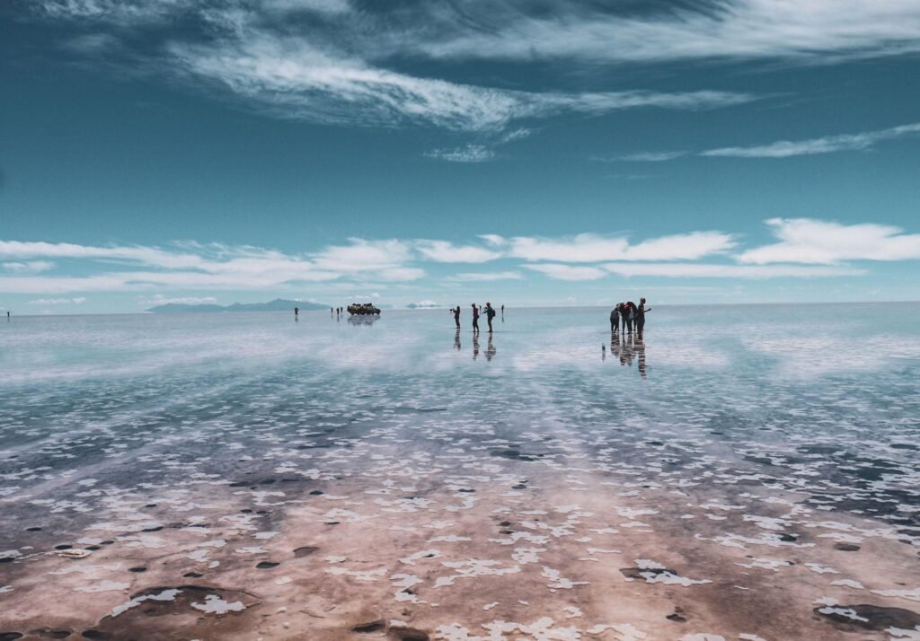 People silhouette and reflections in the Salar de Uyuni, Bolivia