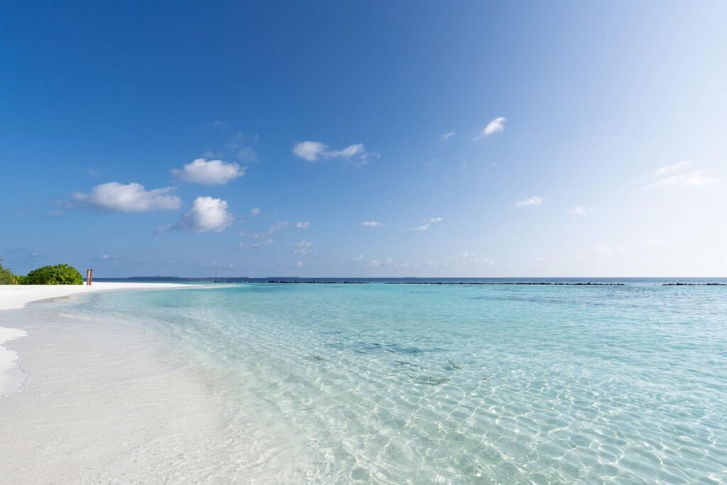 Pristine white sand beach meeting crystal clear turquoise water in the Maldives