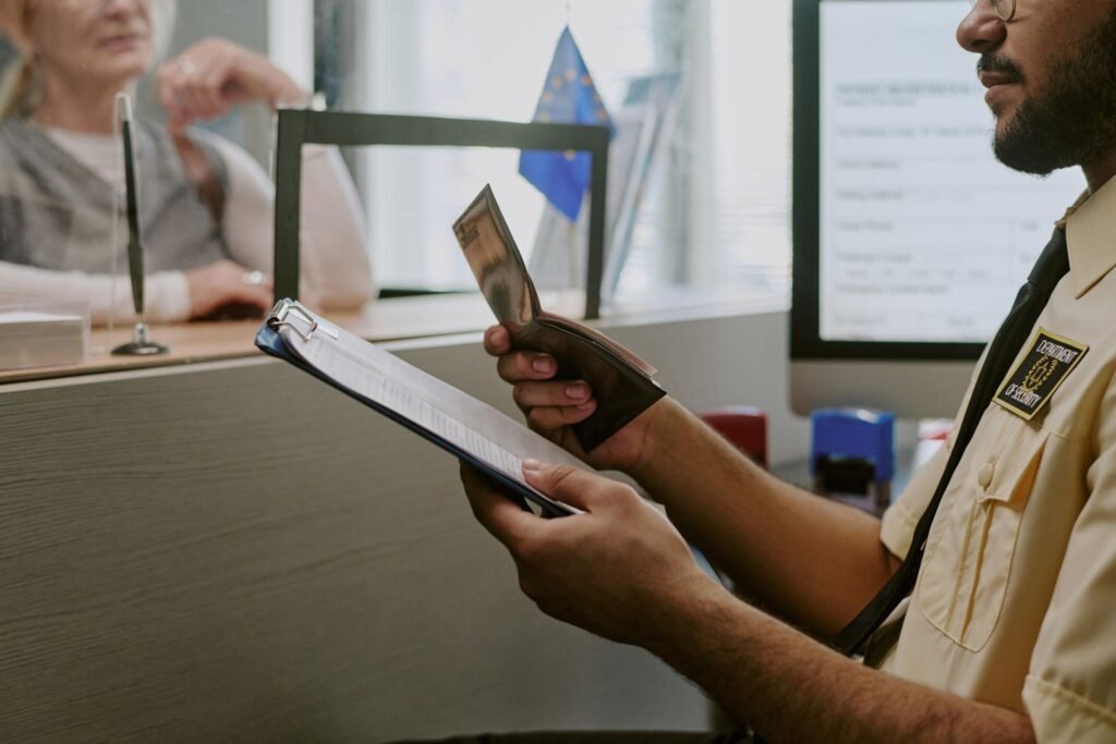 Reviewing Passport at Immigration Desk Handing Documents