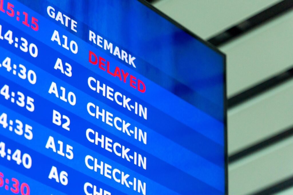 Airport departure information board showing flight status with delayed notice.