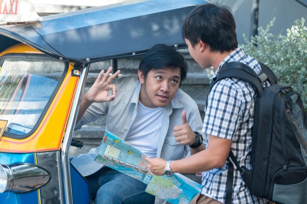 Asian travel photographer negotiates price with tuk tuk driver before traveling around Bangkok Landmark Thailand.
