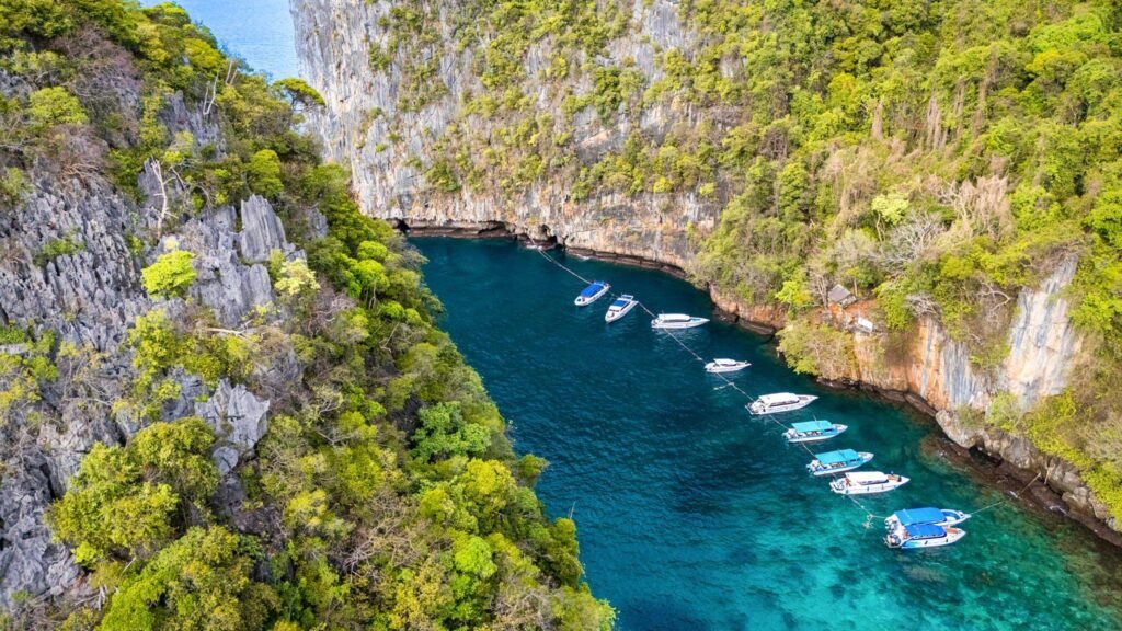 Tourists take a boat trip to see the beach on a small island near Koh Phi Phi in Thailand.