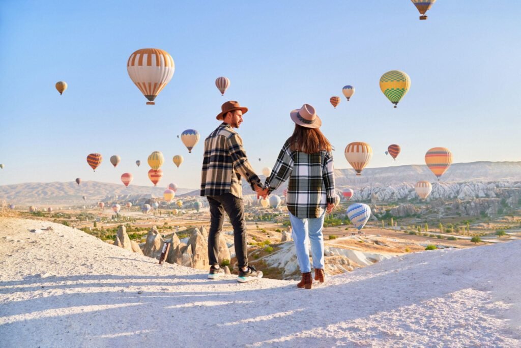Couple travelers vacations together in beautiful destination in Goreme, Turkey. Fabulous Kapadokya with flying air balloons at sunrise, Anatolia