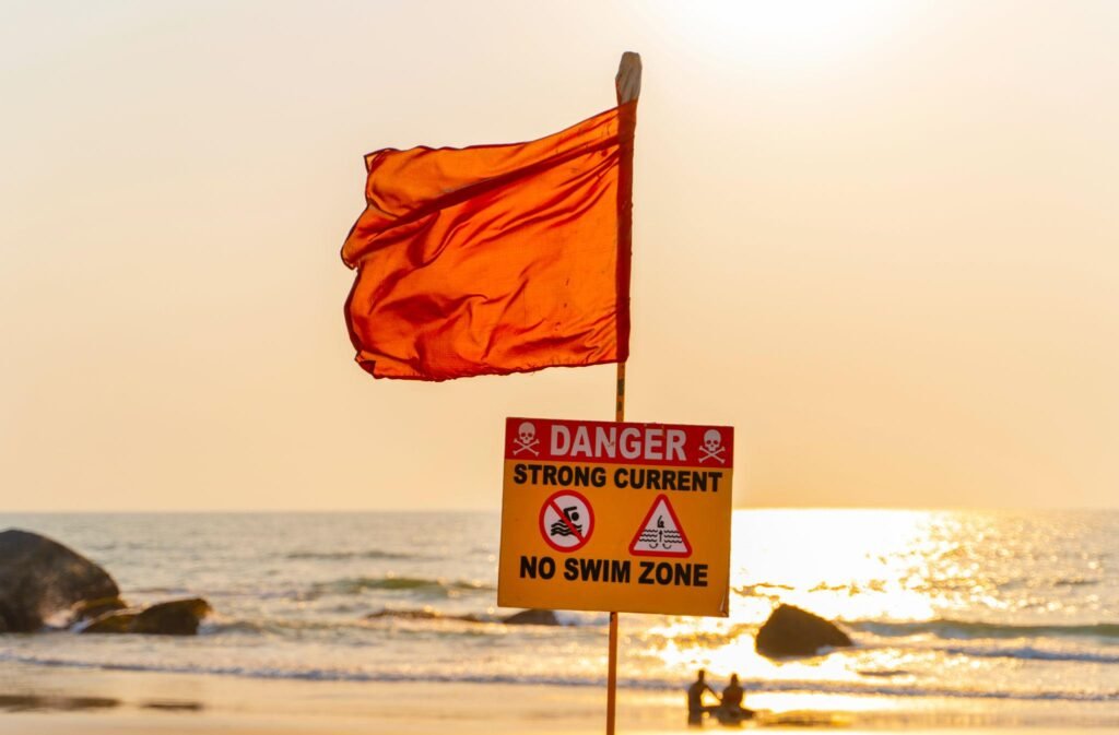 No swimming sign with red flag on the beach of Goa
