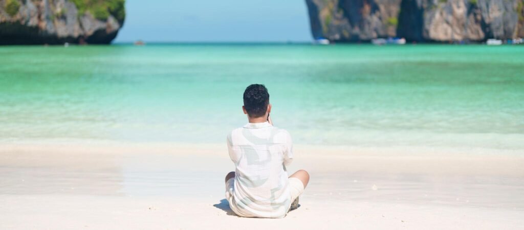 man tourist traveling and sightseeing in Krabi, Thailand, happy traveller enjoy at Maya Bay beach on Phi Phi island, Popular paradise island, destination, Southeast Asia Travel, vacation and holiday