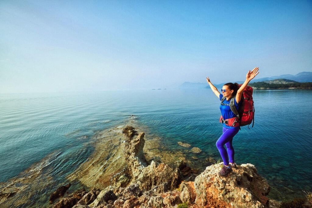 Adventure trek along the coast with a backpack in the summer.