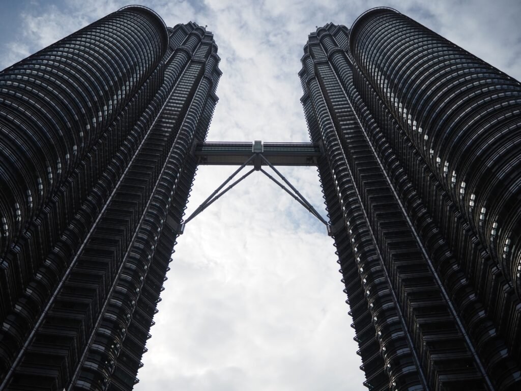 Dramatic low angle shot of the iconic Petronas Twin Towers in Kuala Lumpur.
