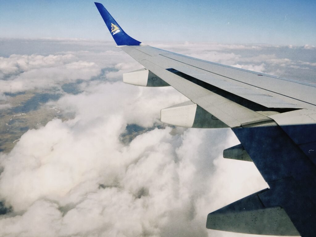 Wing view from a plane flying over Kazakhstan clouds on a clear day.