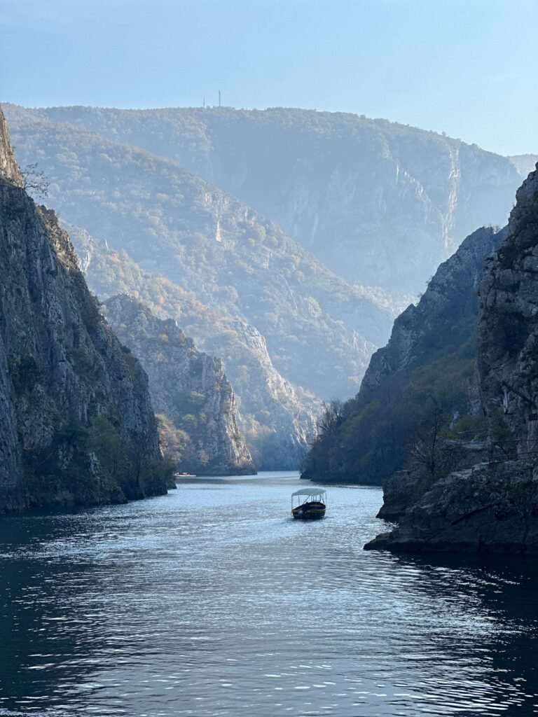 A tranquil boat journey through a majestic river canyon surrounded by towering cliffs.