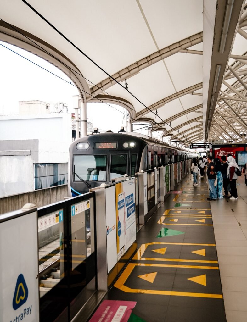 Modern transportation scene at Jakarta MRT station with commuters boarding the electric train.
