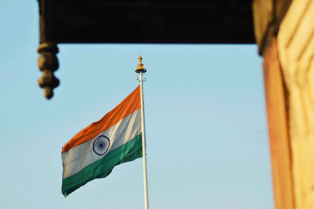 Indian national flag waving proudly against a clear blue sky, symbolizing patriotism.