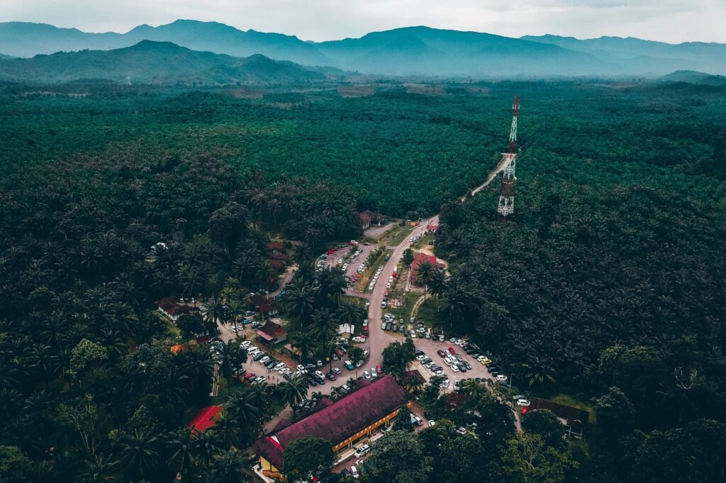 Picturesque drone view of tropical resort hotel located in lush green forest surrounded by mountainous terrain