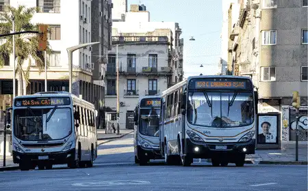 Public city buses traveling along a downtown street in Montevideo, Uruguay