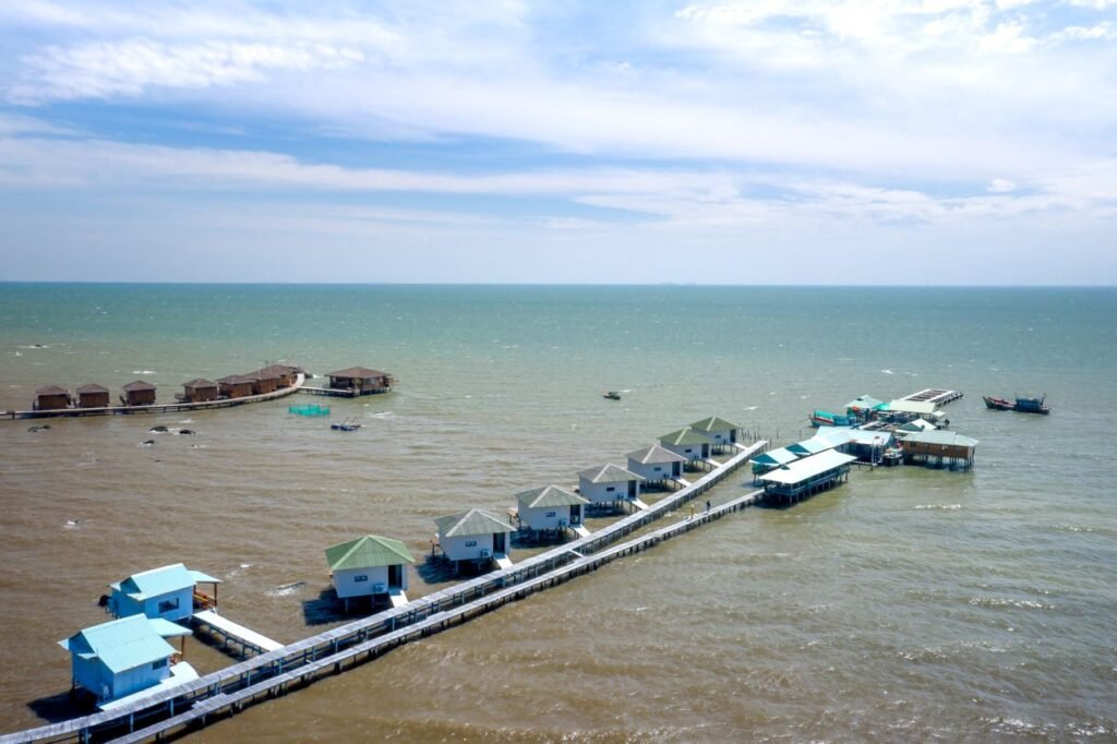 Aerial view of floating villas on the calm sea, showcasing serene coastal architecture.