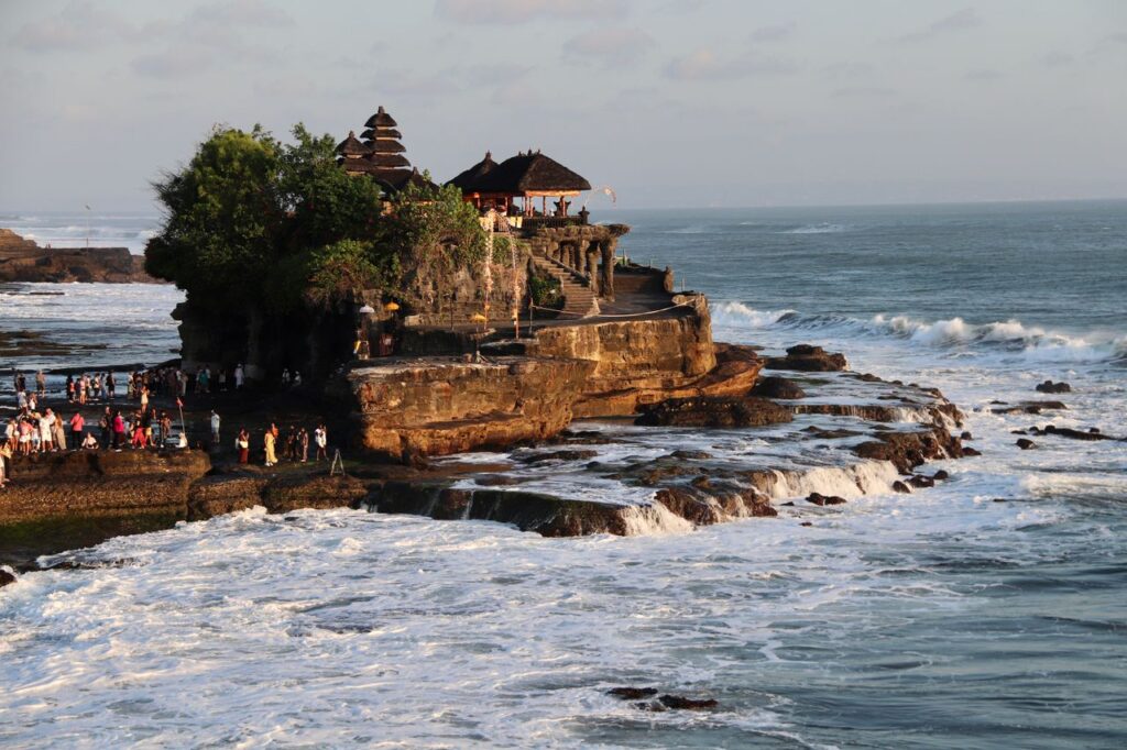 Breathtaking view of Tanah Lot Temple on the rocky coast of Bali, Indonesia, during sunset.