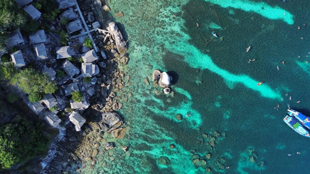 Explore the stunning coastline and clear waters of Ko Tao, Thailand from above.