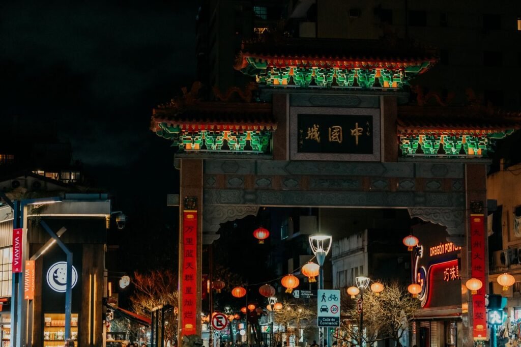 Vibrant night scene of a beautifully lit traditional Chinese archway in a bustling city Chinatown.