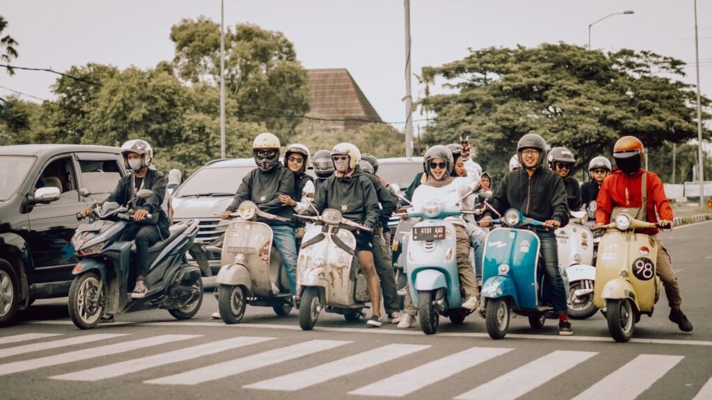 A lively group of scooter riders waiting at a crosswalk in East Java, Indonesia.