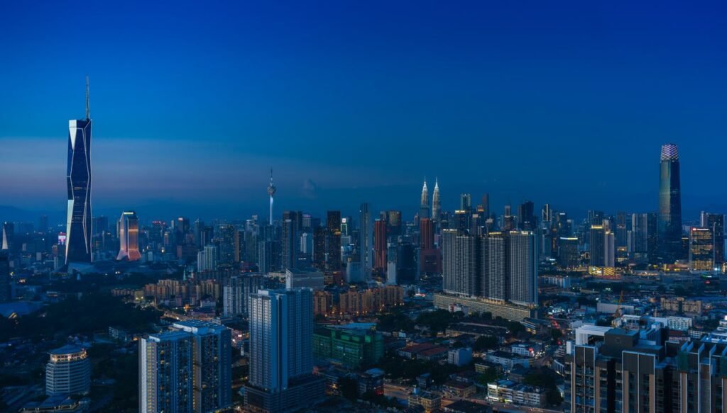 Discover the vibrant Kuala Lumpur skyline featuring iconic landmarks in the evening glow.