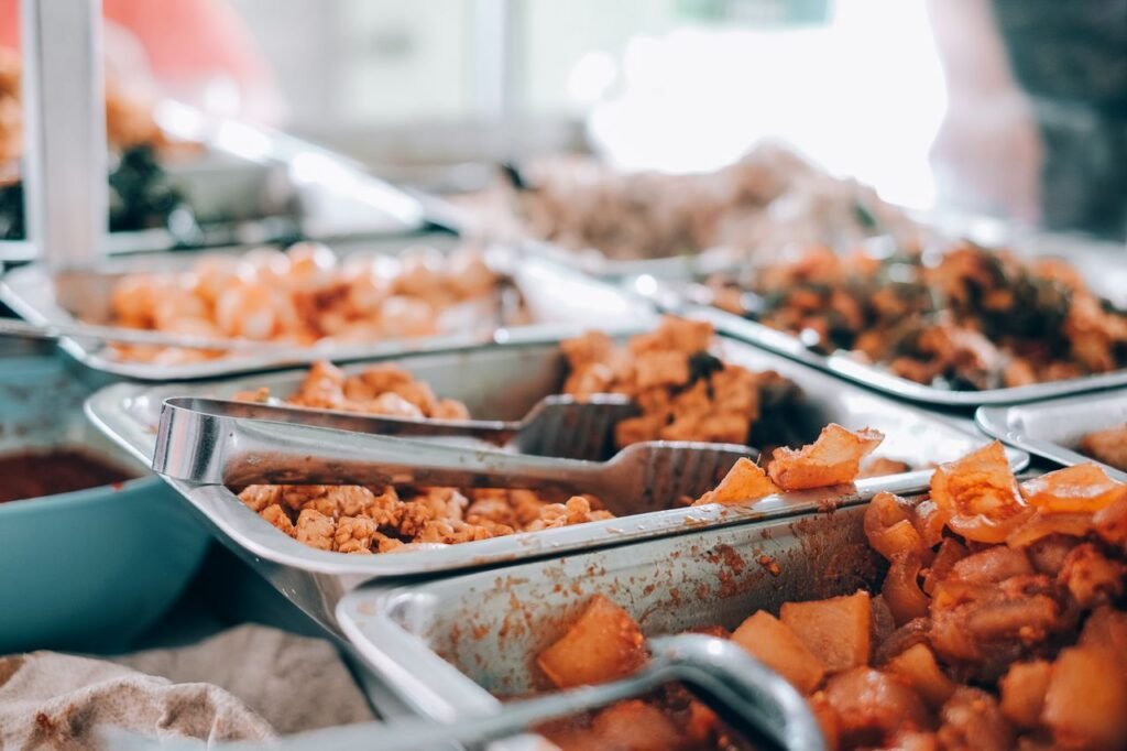 An inviting display of various hot buffet dishes in stainless steel trays, perfect for food enthusiasts.