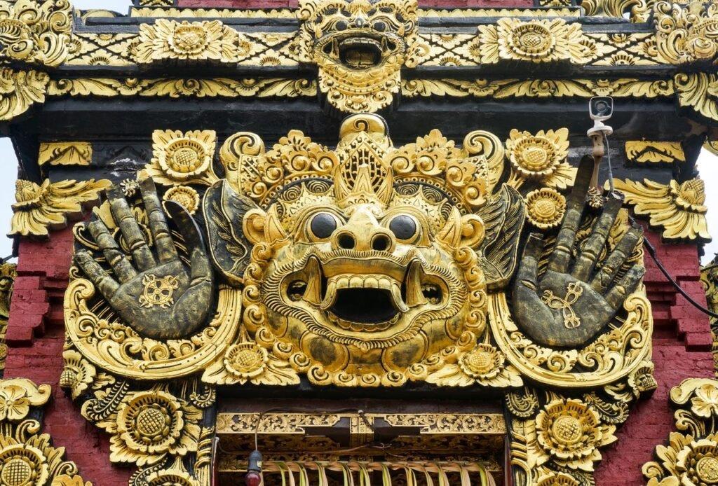 A detailed view of an ornate Balinese temple carving with gold embellishments and traditional motifs.