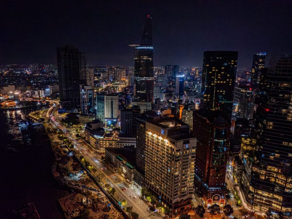 A stunning aerial view of Ho Chi Minh City's skyline at night, featuring illuminated skyscrapers.