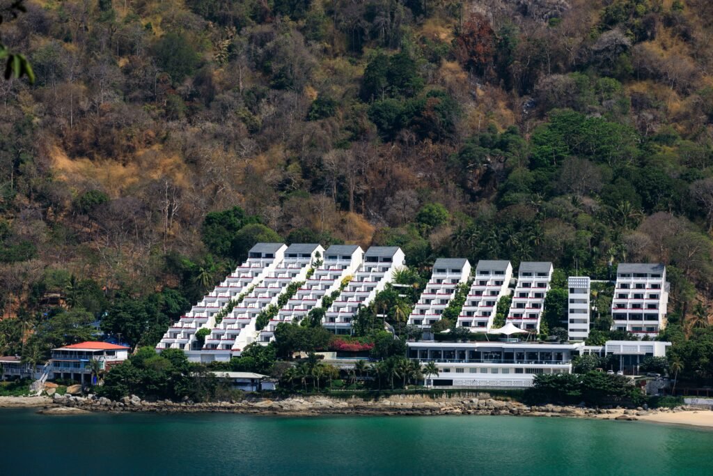 A scenic view of a modern resort nestled on the lush coastline of Phuket, Thailand.