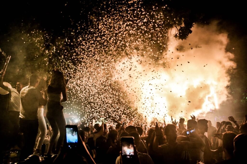 Exciting nighttime party scene with a crowd celebrating amidst a vibrant confetti burst.