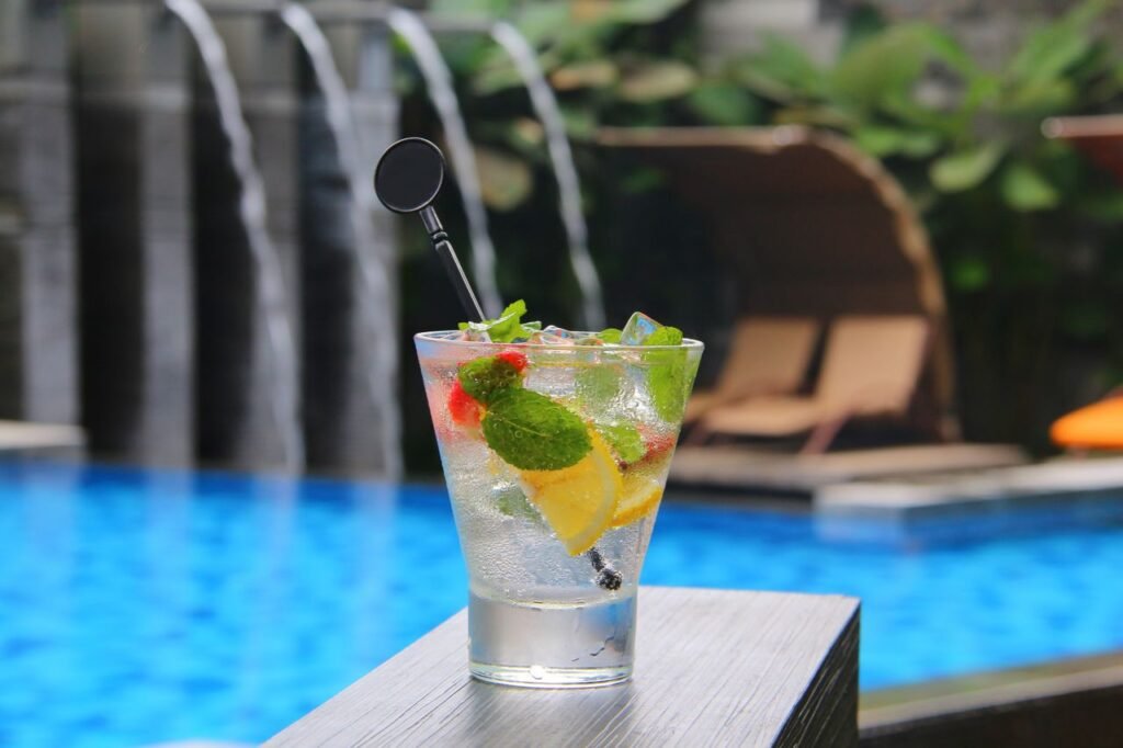 A close-up of a refreshing mojito with lemon and mint by a tropical poolside in Bali, Indonesia.