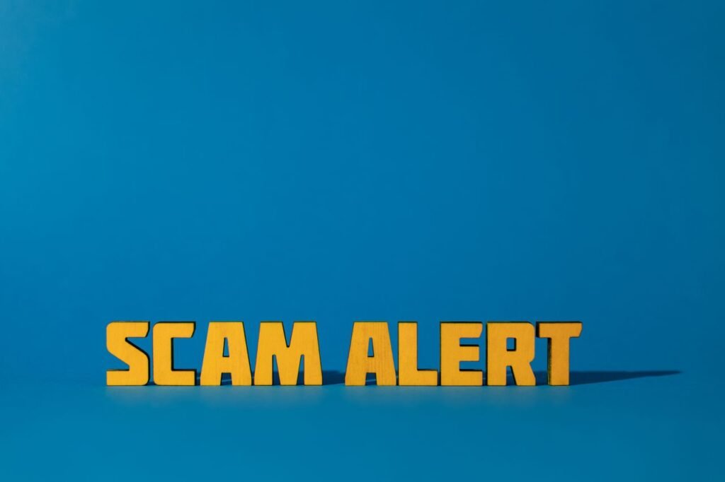 Bold yellow 'Scam Alert' text on a vivid blue surface, emphasizing warning and caution.