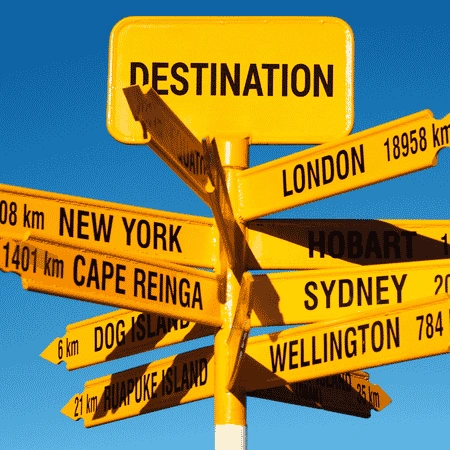 Yellow destination signpost pointing to cities including London, New York, Sydney, Wellington, and Hobart