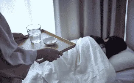 Traveler resting in a hotel room while taking medicine with a glass of water during a trip