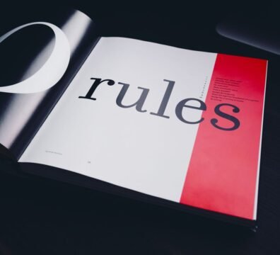 Close-up of an open book page featuring the word 'rules' with a black background.