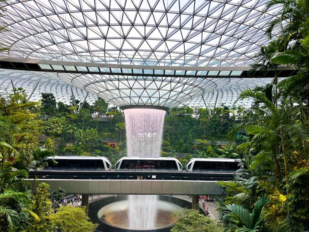 Futuristic indoor waterfall and greenery at Jewel Changi Airport, Singapore.