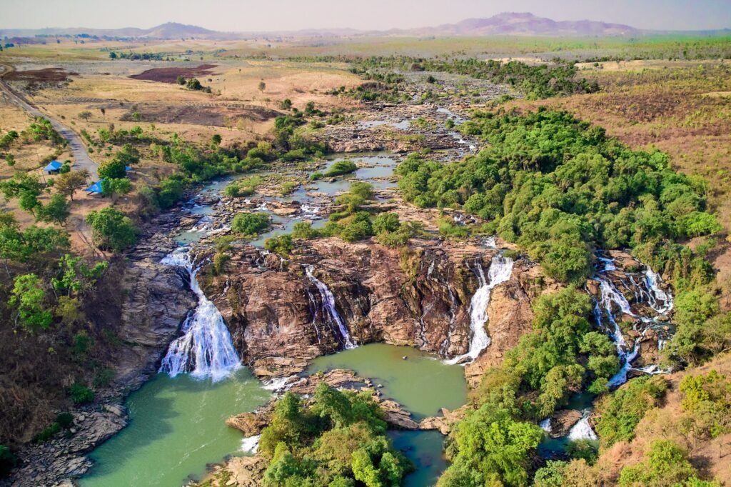 Breathtaking aerial view of waterfalls and lush landscape in Nigeria.