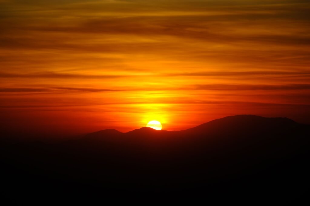 Capture of a vivid sunset over Mount Nemrut in Adıyaman, Türkiye, highlighting vibrant colors and silhouettes.