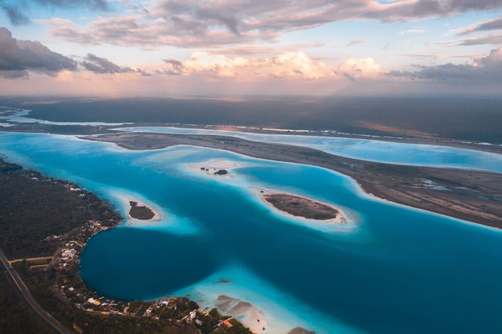 Breathtaking aerial view of a clear blue lagoon along the Mexican coastline at sunset.