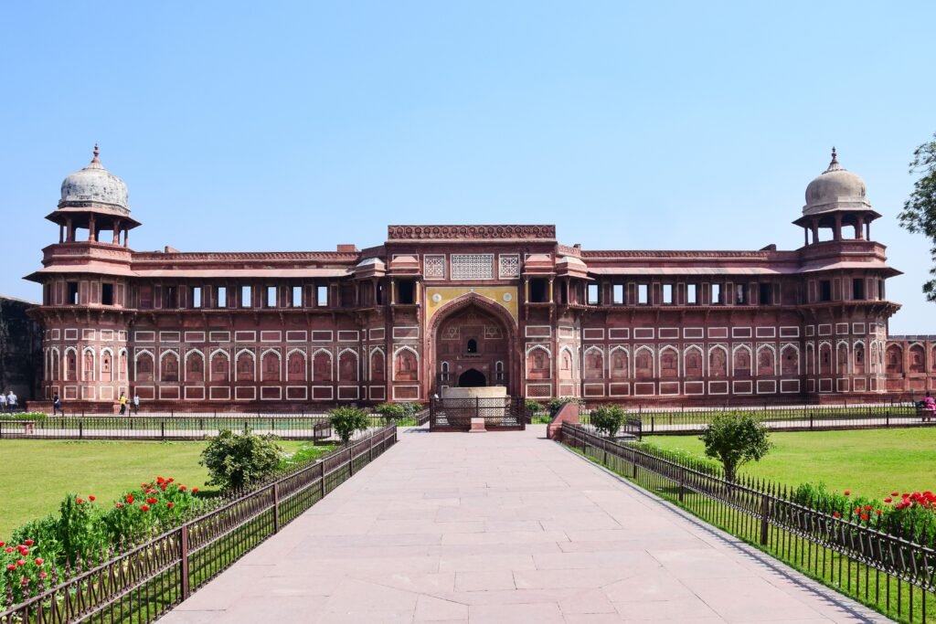 View of the historic Agra Fort's stunning architecture against a clear blue sky.