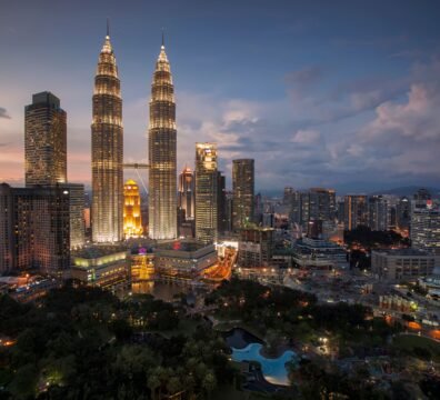 Stunning Kuala Lumpur skyline featuring the illuminated Petronas Towers at twilight.