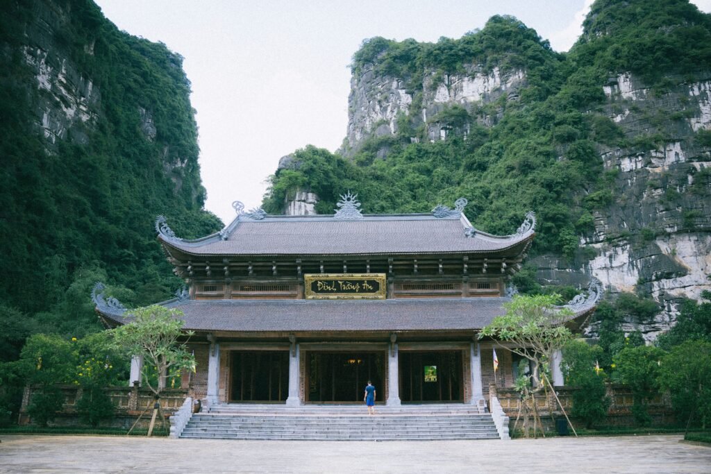 A serene view of a traditional pagoda in Ninh Bình, surrounded by lush green hills.