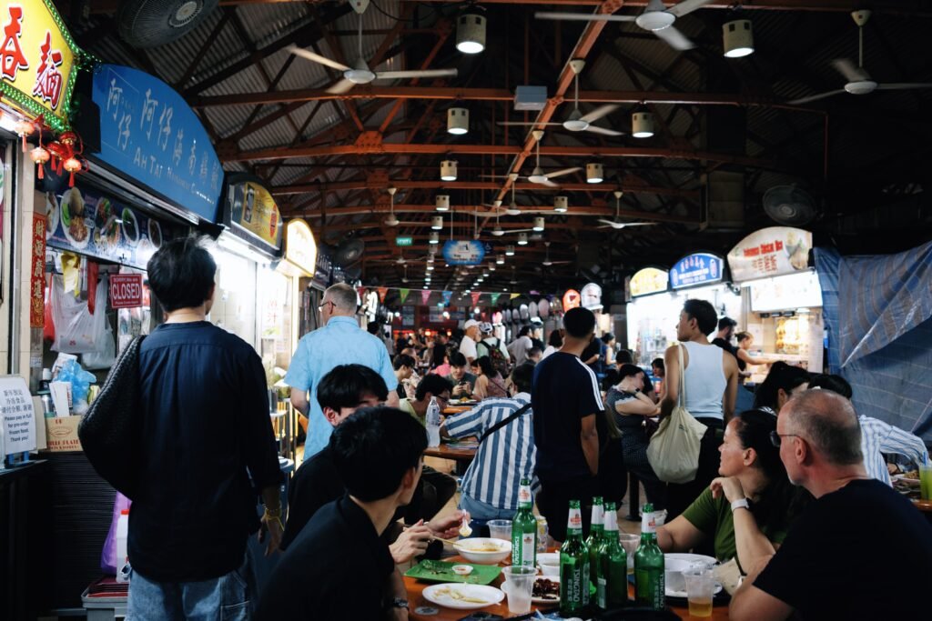 A bustling evening at Maxwell Food Centre in Singapore filled with diners enjoying local dishes.