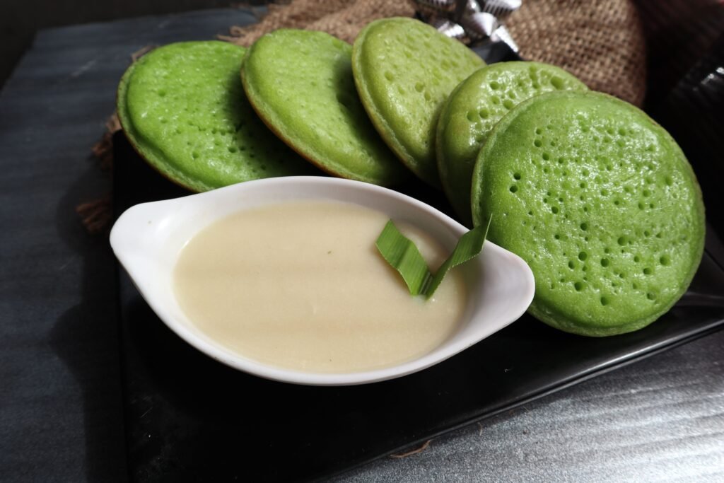 Close-up of Indonesian Serabi pancakes with a coconut sauce, highlighting a traditional sweet Asian cuisine.