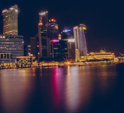 Stunning view of the illuminated Singapore cityscape reflecting on water at night.